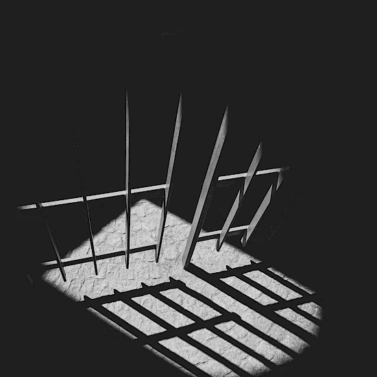 Ausschnitt einer Gefängnistür, die durch das Licht eines Fensters beleuchtet wird, Bild in schwarz-weiß
