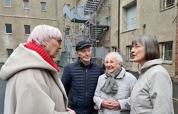 Claudia Roth mit drei weiteren Besucher:innen des ehemaligen Frauengefängnisses Hoheneck vor dem Gebäude.